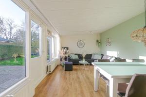 a living room with a couch and a table at Duinland 251 - Park Duinland Sint Maartenszee in Sint Maartensvlotbrug