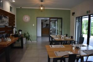 Symponia Guesthouse في Ghanzi: مطعم بطاولات خشبية وجدران خضراء