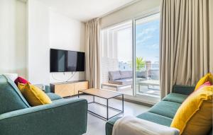a living room with two blue couches and a tv at Beautiful Apartment In Chipiona in Chipiona