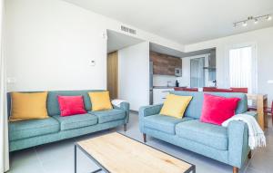 a living room with two blue couches with colorful pillows at Stunning Apartment In Chipiona With Wi-fi in Chipiona