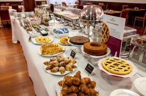 a table with various pastries and cakes and pies at Crowne Plaza Venice East, an IHG Hotel in Quarto dʼAltino