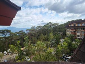 - une vue sur une ville arborée et un bâtiment dans l'établissement The Forest Lodge at Camp John Hay privately owned unit with parking 535, à Baguio