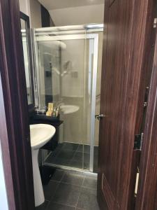 La salle de bains est pourvue d'une douche, d'un lavabo et de toilettes. dans l'établissement The Forest Lodge at Camp John Hay privately owned unit with parking 535, à Baguio