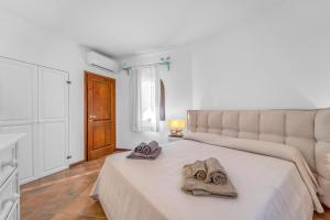 1 dormitorio con 1 cama con toallas en -LUXURY- Torretta con Piscina e Spiaggia a 300 MT, en Liscia di Vacca