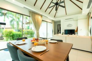 a dining room with a wooden table and chairs at Phuket Boutique Pool Villa-80 in Rawai Beach