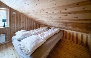 uma cama num quarto com uma parede de madeira em 2 Bedroom Gorgeous Home In Aust- Torpa em Aust-Torpa