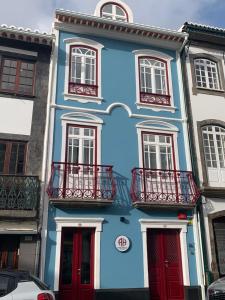 a blue building with red doors and windows at Angra Heritage - City Center Hostel in Angra do Heroísmo