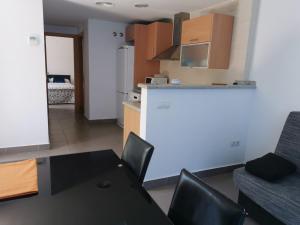 cocina y sala de estar con mesa y sillas. en Casa en Bassetes LOCDENIA, en El Verger