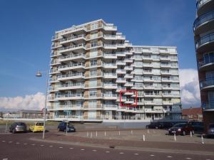 een groot appartementencomplex met een rood nummer erop bij Sterflat 83 in Egmond aan Zee