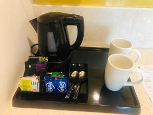 a tray with two coffee mugs and cups on a counter at Holiday Inn Amritsar Ranjit Avenue, an IHG Hotel in Amritsar