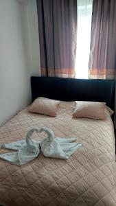 albornoz en la parte superior de una cama con ventana en Apartment BN MAGIC, en Bijeljina