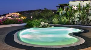 una piscina en un jardín por la noche en -LUXURY- Torretta con Piscina e Spiaggia a 300 MT, en Liscia di Vacca