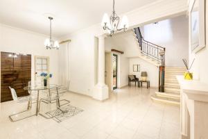 - un salon avec une table et un escalier dans l'établissement Enormous luxury 3-storey townhouse, rooftop EGAS1-1, à Il-Furjana