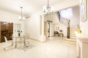 un soggiorno con un tavolo e una scala di Enormous luxury 3-storey townhouse, rooftop EGAS1-1 a Floriana