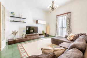 un soggiorno con divano e TV a schermo piatto di Enormous luxury 3-storey townhouse, rooftop EGAS1-1 a Floriana