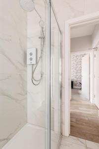 a shower with a glass door in a bathroom at Sea Breeze Apartments in Bournemouth +132 photos