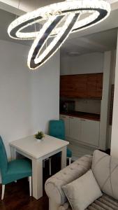 sala de estar con sofá, mesa y lámpara de araña en Apartment BN MAGIC, en Bijeljina