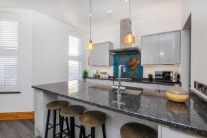 a kitchen with a large counter with stools at The Residence At The Lawrence Apartments in York