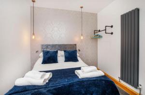 een slaapkamer met een groot bed met blauwe kussens bij The Residence At The Lawrence Apartments in York