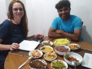 a man and a woman sitting at a table with food at Villu Villa in Anuradhapura