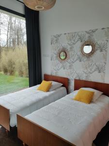 two beds in a bedroom with a window at Maison d'architecte avec SPA in Concarneau