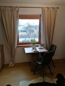 a table and a chair in front of a window at Haus Miriam in Mieming