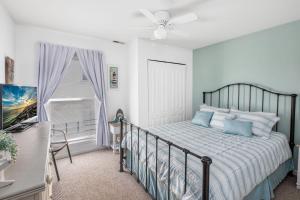 een slaapkamer met een bed, een plafondventilator en een raam bij Beach Block 3 Bedroom in WW Crest in Wildwood