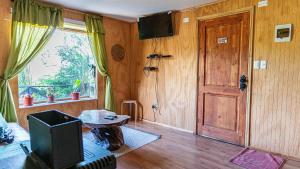 a living room with a television and a door at Cabañas Estrella del Sur in Puerto Varas