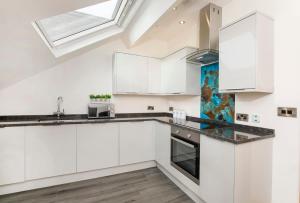 a kitchen with white cabinets and a skylight at The Hideaway At The Lawrence Apartments in York
