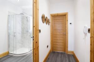 a bathroom with a shower and a glass door at The Hideaway At The Lawrence Apartments in York