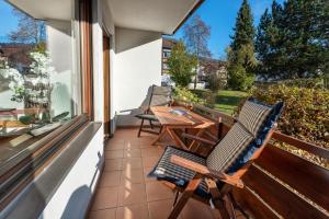 a patio with two chairs and a table on a balcony at Staufenhirsch Apartment in Oberstaufen