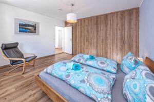 a bedroom with two beds and a chair at Staufenhirsch Apartment in Oberstaufen