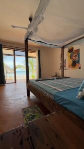 1 dormitorio con 1 cama y vistas al océano en Bwereu Sunset Villas 