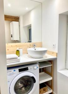 a bathroom with a washing machine and a sink at LE PETIT LANDAIS - Chaleureux in Mont-de-Marsan