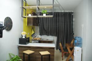 a kitchen with a sink and a counter with stools at Enn lovely apartment 10 in Bungoma