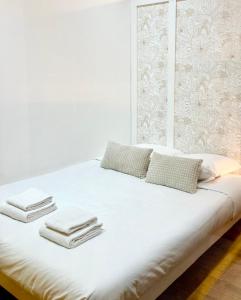 a white bed with towels and pillows on it at Le Petit Landais - Chaleureux - Clim - Central in Mont-de-Marsan +8 photos
