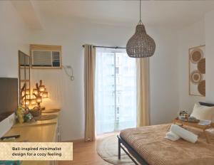 1 dormitorio con 1 cama y luz colgante en The Traveller's Haven Airbnb, en Cebú
