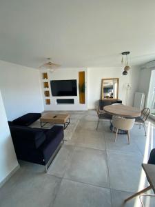 een woonkamer met een bank en een tafel bij Splendide 70m2 Balcon + Parking in Clermont-Ferrand
