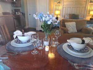 una mesa con platos y vasos y un jarrón de flores en Piano Room Studio with full kitchen and no fees en Florence
