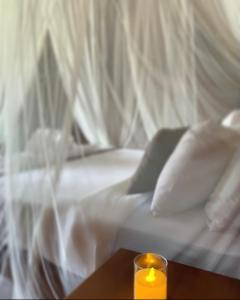 uma vela sentada numa mesa ao lado de uma cama em Maharatu Villa Lembongan em Nusa Lembongan