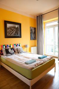 a bedroom with a large bed with yellow walls at Pepe Hostel in Warsaw