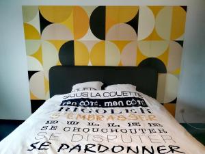 a bedroom with a bed with a yellow and black wall at La Citronnade in Floreffe