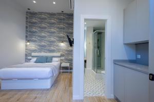 a bedroom with a white bed and a bathroom at FLORIT FLATS - The Mediterraneo Apartments in Valencia