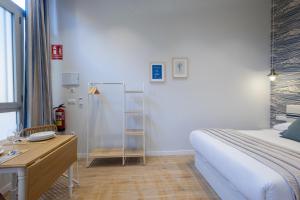 a bedroom with a bed and a desk and a desk at FLORIT FLATS - The Mediterraneo Apartments in Valencia