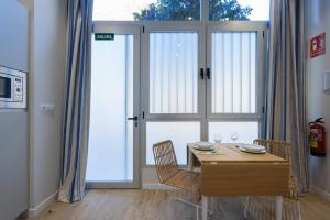バレンシアにあるFLORIT FLATS - The Mediterraneo Apartmentsのダイニングルーム(テーブル、椅子、窓付)