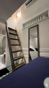 a mirror in a room with a ladder and a bed at Mar & Ilha - Guest House - Praia de Maresias in São Sebastião
