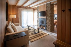 uma sala de estar com um sofá e uma lareira em RentUp - Vistas panoramicas y comodidades de lujo, Vila Master em San Martín de los Andes