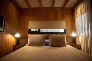 - une chambre avec un lit avec deux oreillers et deux lumières dans l'établissement RentUp - Vistas panoramicas y comodidades de lujo, Vila Master, à San Martín de los Andes