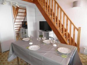 una mesa con platos y copas de vino. en Appartement Gruissan, 1 pièce, 6 personnes - FR-1-229-65, en Gruissan