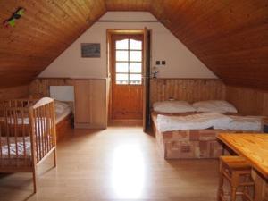 a attic bedroom with two beds and a window at Domeček Karlov in Malá Morávka